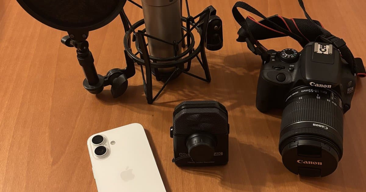 Móvil, grabadora de vídeo Zoom, micrófono de condensador y cámara Canon sobre una mesa de madera, listos para grabar una sesión de batería